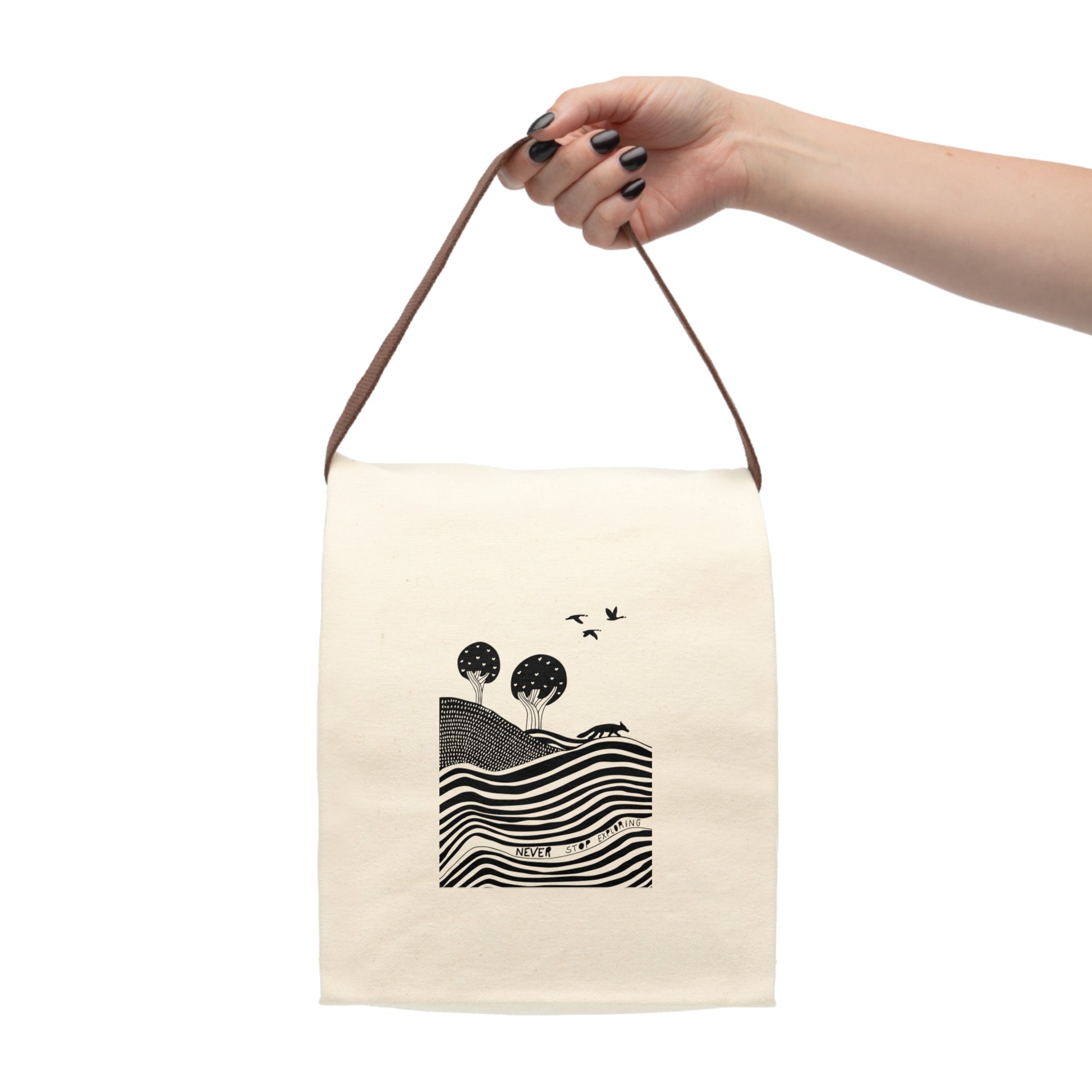 Beige tote bag with black and white design held by a hand on a white background