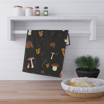 Black towel with mushroom pattern hanging on a wooden shelf with kitchen items.