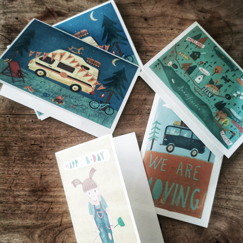 Five colorful  illustrated greeting cards laid out on a table